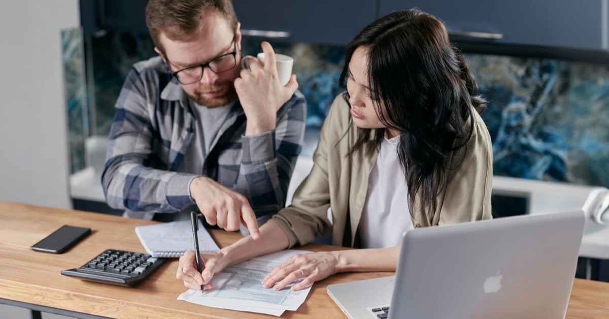 Person reviewing debt consolidation documents at a desk with a pen and calculator