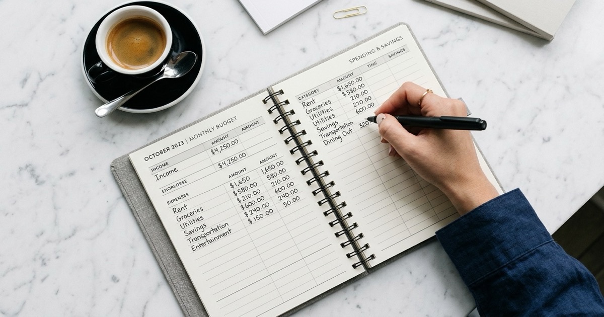 Fountain pen, leather notebook, small ceramic espresso cup, and eucalyptus on linen in warm morning light