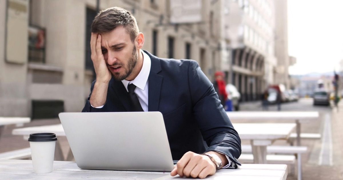Person reviewing and correcting a handwritten budget in a notebook at a clean desk