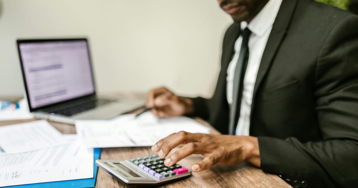 Person reviewing retirement planning documents at a desk with notes and a pen
