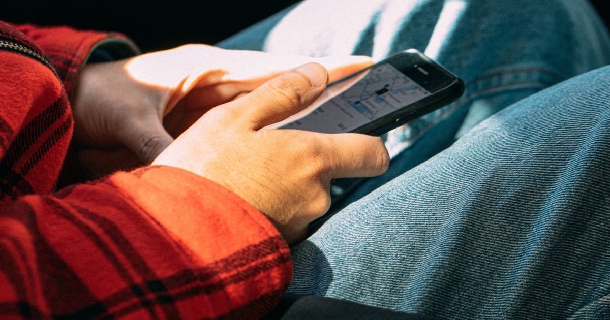 Person reviewing a ride receipt on a smartphone while seated near a window