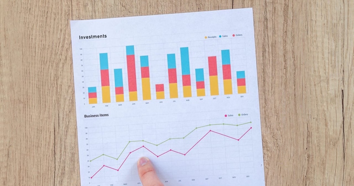 Colorful painted eggs distributed across three woven wicker baskets on a farmhouse table