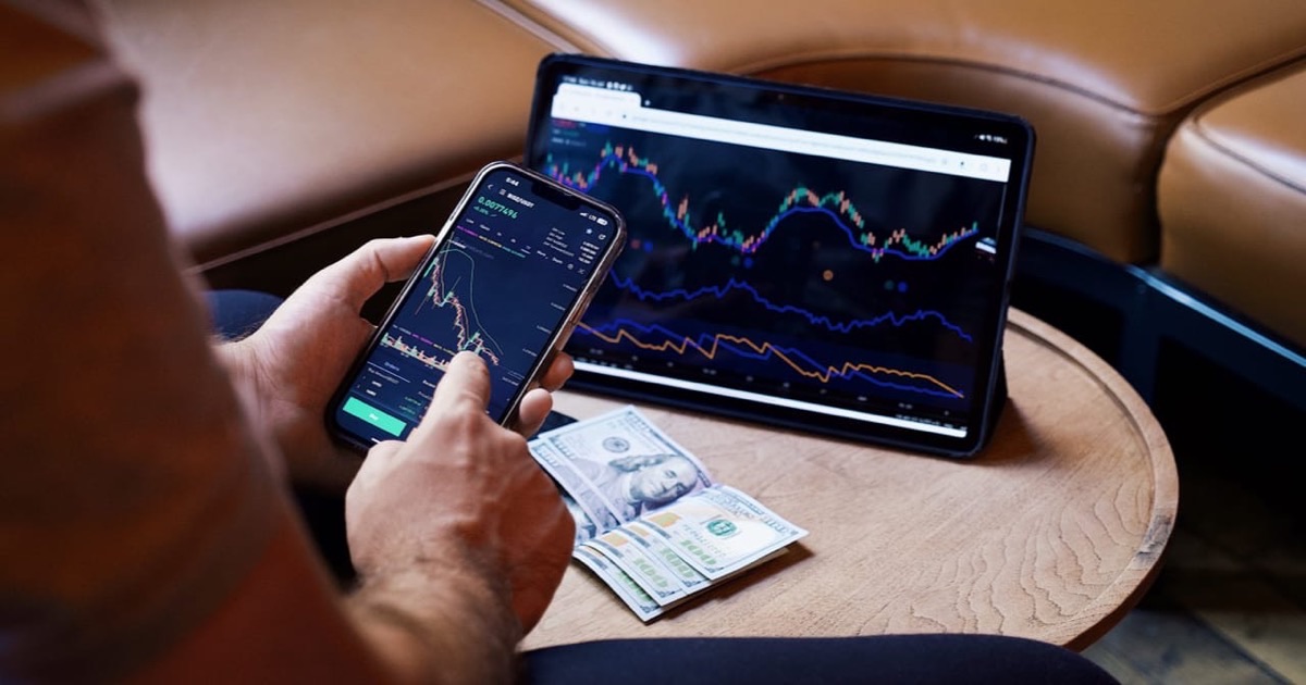 Person reviewing an investment portfolio summary document at a desk with charts