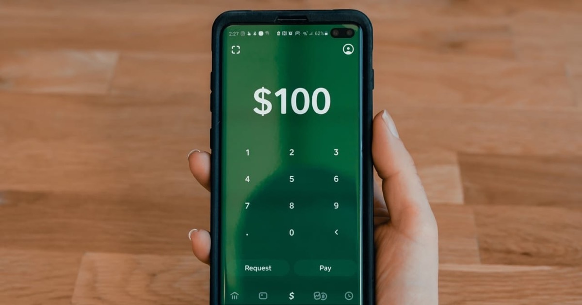 Person reviewing PayPal subscription settings on a device with billing documents nearby