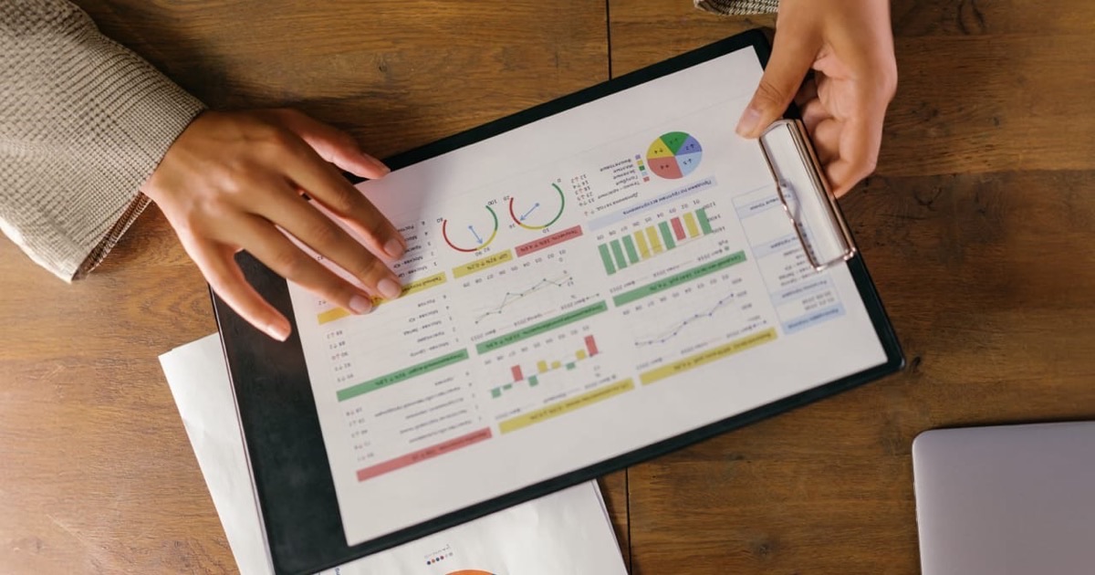 Person reviewing a credit report document with notes at a bright modern desk