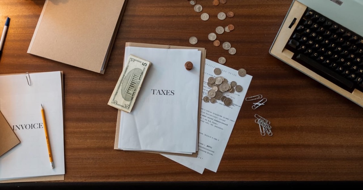 Two professionals reviewing tax comparison documents side by side at a clean desk