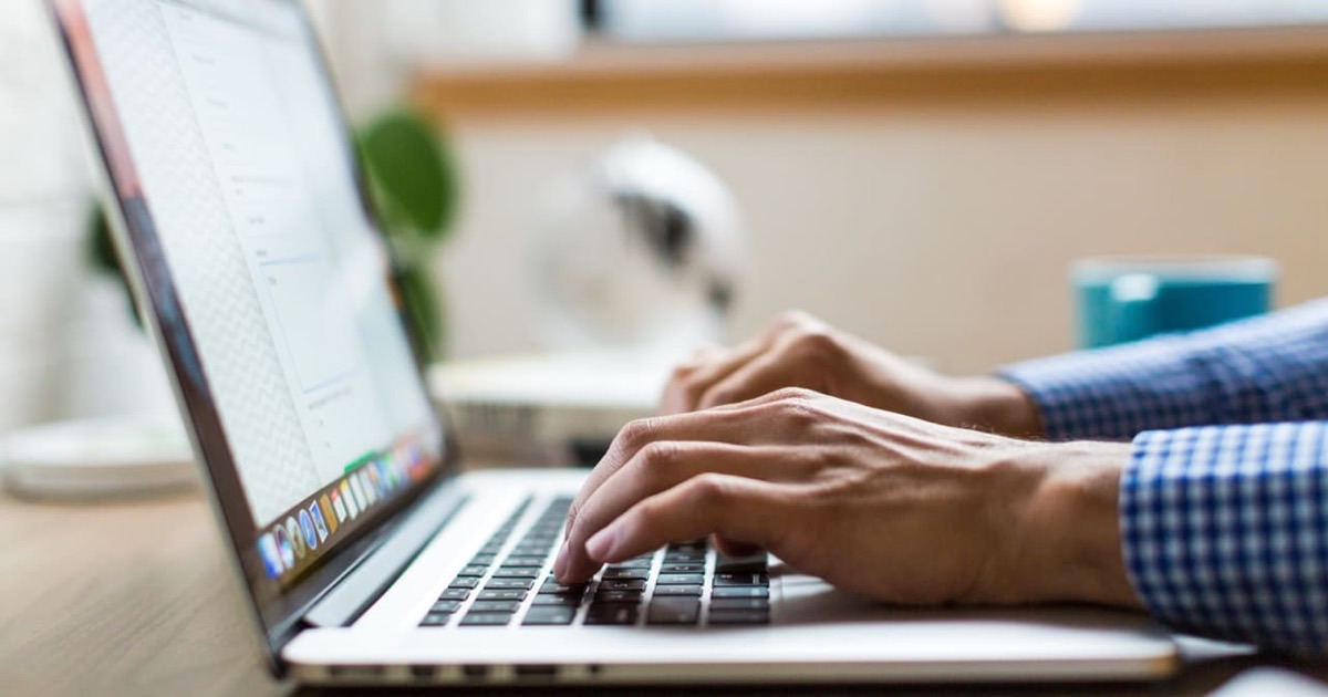 Person composing a professional email on a smartphone at a clean modern white surface